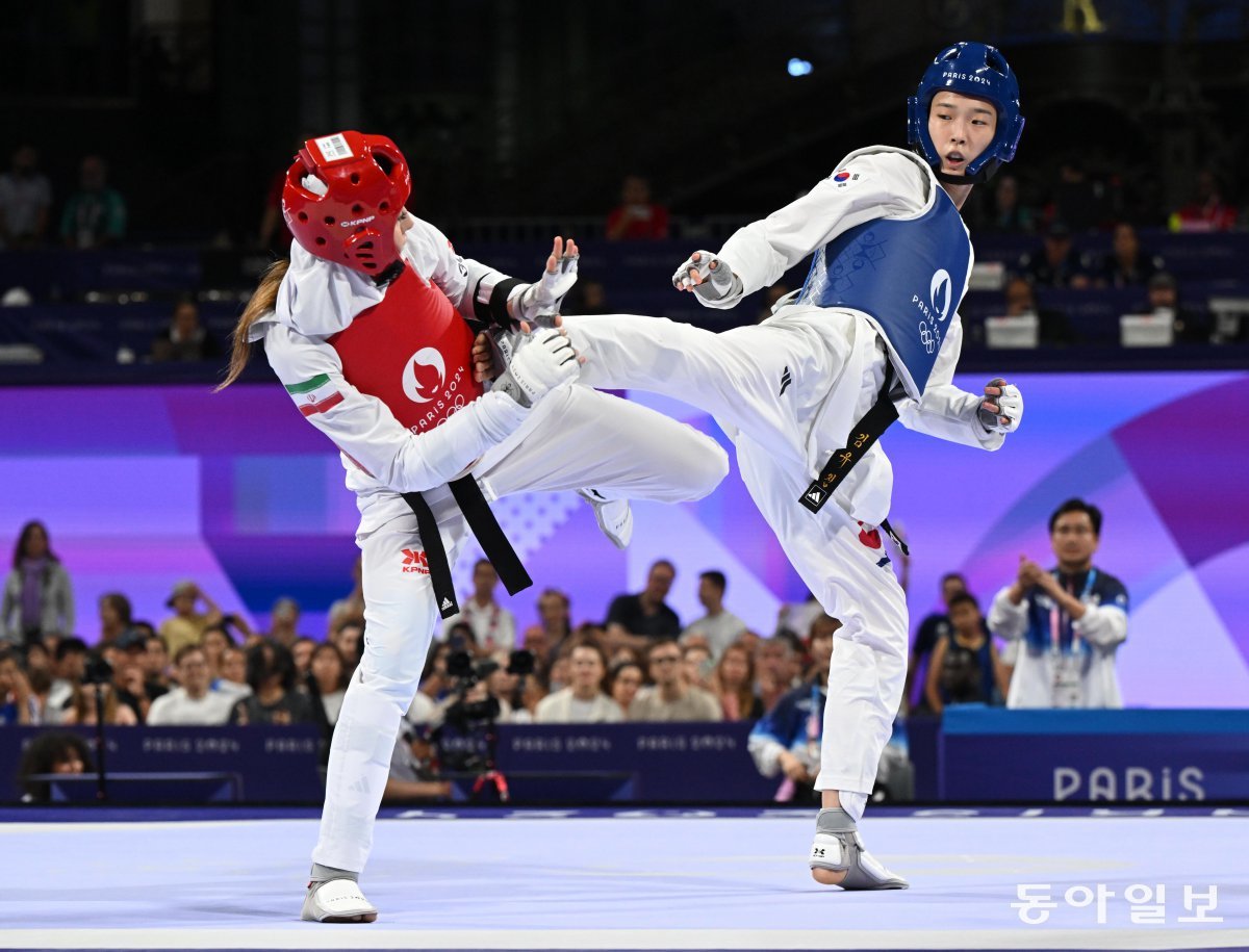 김유진(오른쪽)이 9일 파리 올림픽 태권도 여자 57kg급 결승전에서 나히드 키야니찬데(이란)에게 옆차기 공격을 하고 있다. 키 183cm인 김유진은 8강전부터 결승전까지 긴 다리를 이용한 발차기로 많은 점수를 얻었다. 파리=양회성 기자 yohan@donga.com