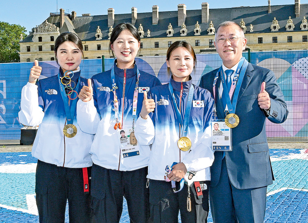 정의선 현대자동차그룹 회장(오른쪽)이 지난달 28일(현지 시간) 파리 올림픽 양궁 여자 단체전에서 금메달을 목에 건 국가대표 선수들과 엄지를 함께 내밀며 기념촬영을 하고 있다. 왼쪽부터 남수현, 임시현, 전훈영, 정 회장. 현대자동차그룹 제공