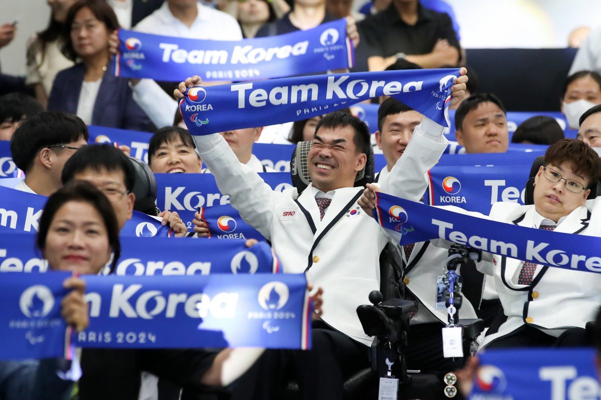 파리 패럴림픽(장애인올림픽)에 참가하는 한국 대표 선수단이 12일 서울 송파구 올림픽파크텔에서 열린 결단식에서 ‘팀코리아’ 문구가 적힌 머플러를 들고 결의를 다지고 있다. 이번 패럴림픽은 29일 오전 3시 개회식을 시작으로 12일간 열전에 들어간다. 대한장애인체육회 제공