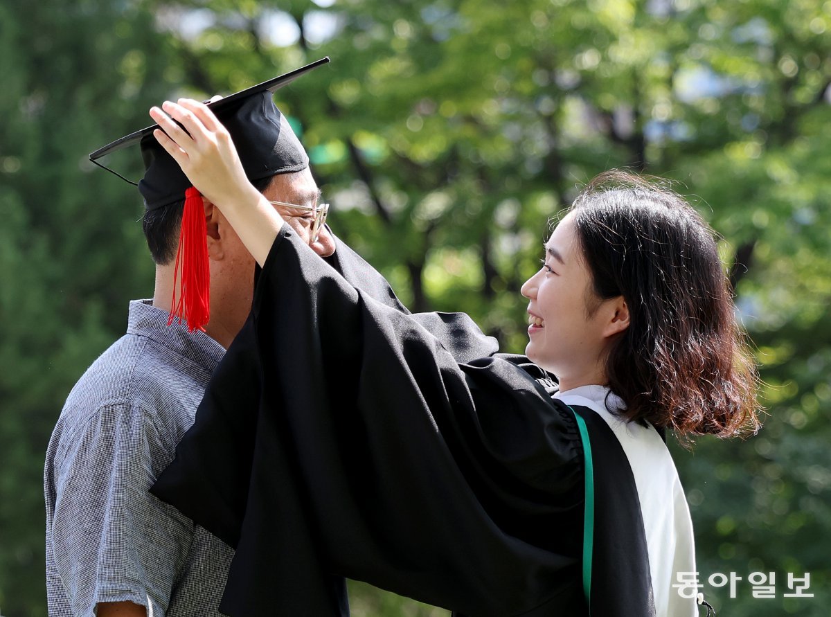 16일 오전 후기 학위수여식이 열린 서울 동대문구 한국외국어대학교에서 한 졸업생이 아버지에게 학사모를 씌워주고 있다. 송은석 기자 silverstone@donga.com