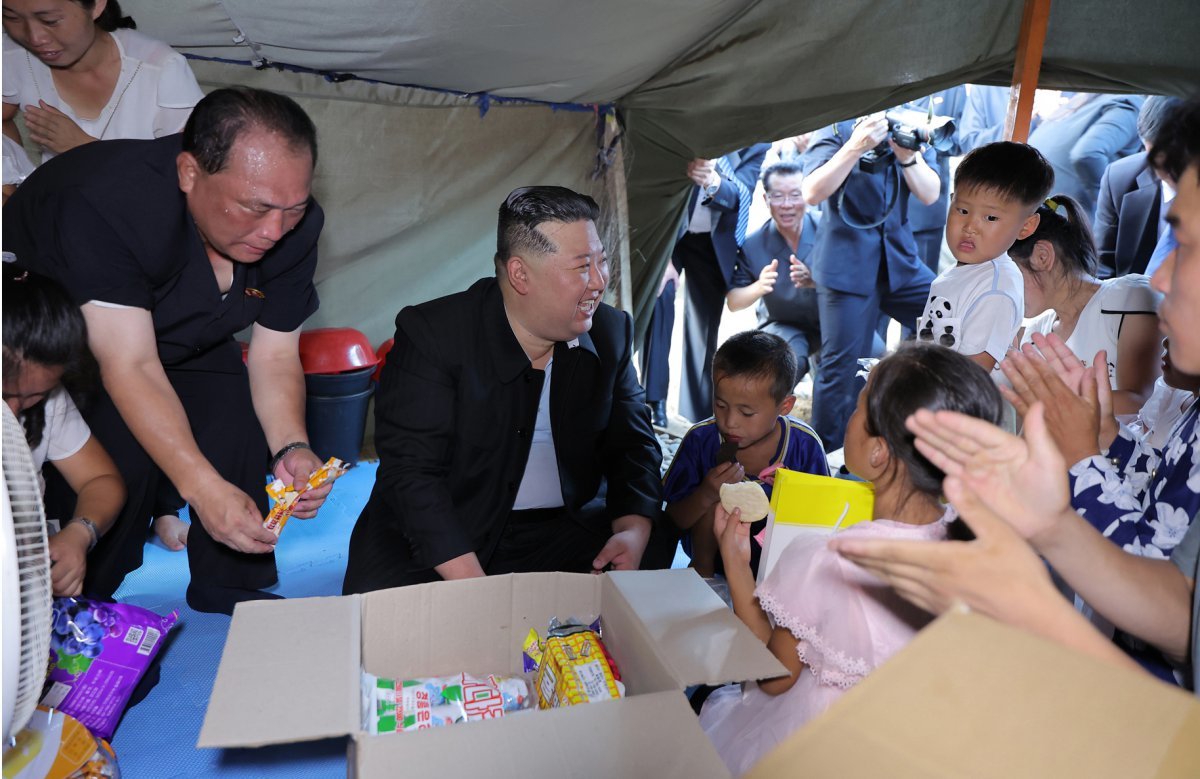 Chairman Kim visits a tent village for flood victims in Uiju County, North Pyongan Province, and distributes snacks and other relief supplies to children. Rodong Sinmun News 1