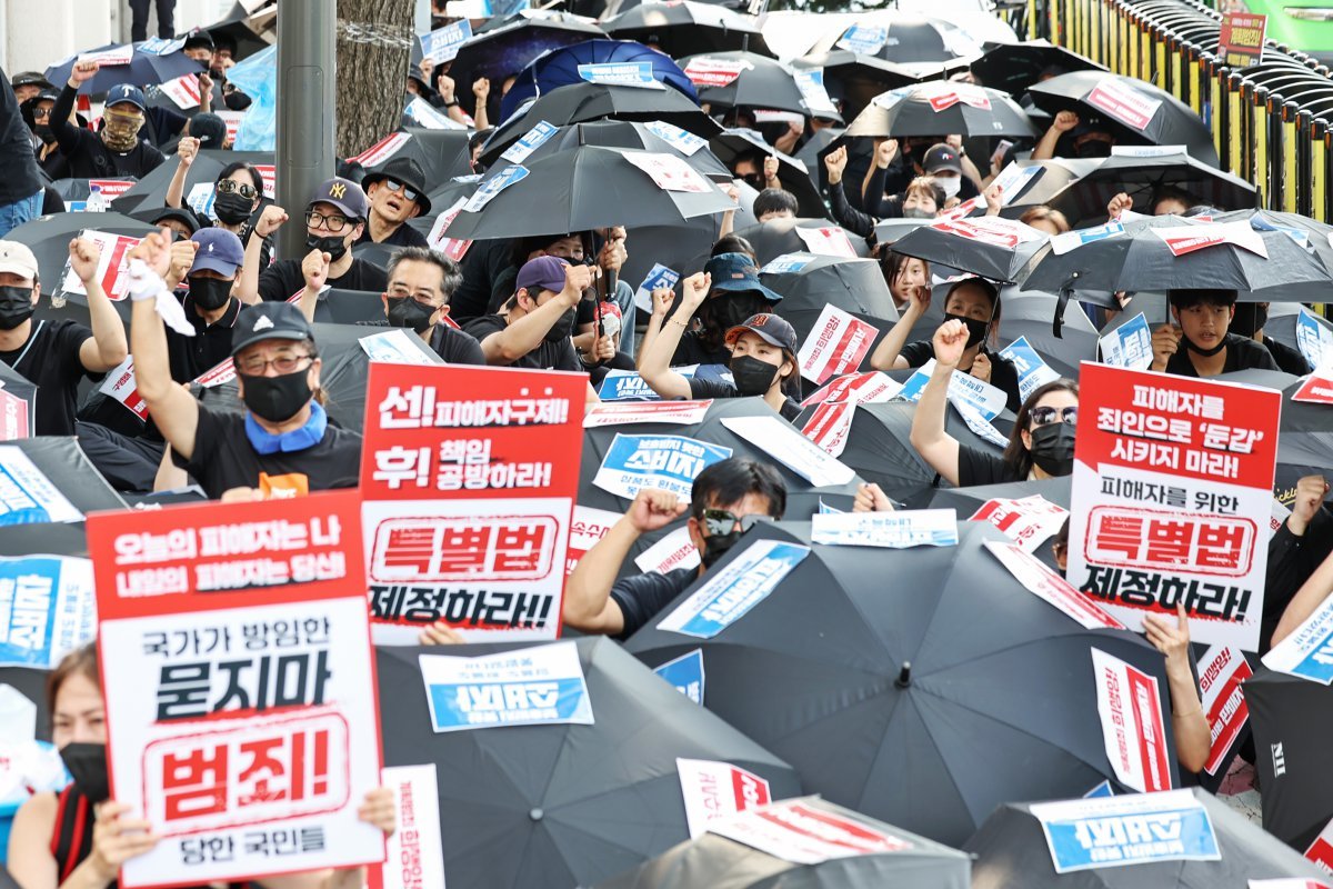 ‘티메프 사태’ 피해자들이 지난 18일 오후 서울 종로구 사직로 일대에서 열린 검은우산 집회에서 구호를 외치고 있다. 이날 참가자들은 정부에 실효성 있는 구제방안 마련과 특별법 제정을 촉구했다. 뉴스1