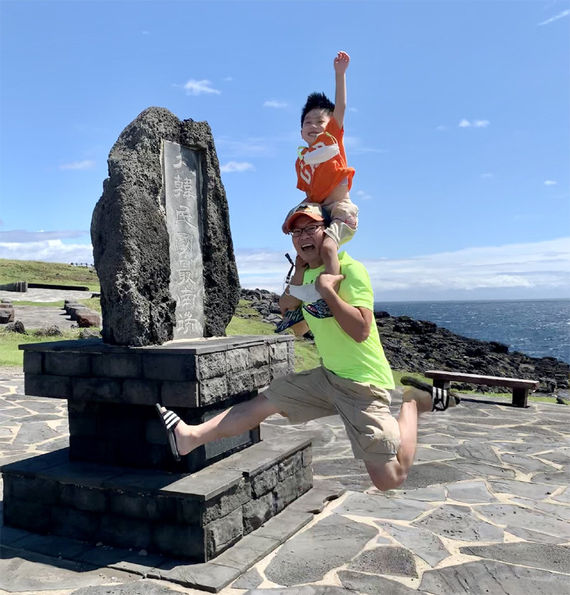 Father and son Kim Dan-woo and Kim Yong-min jumping in front of the southernmost monument of Marado, Seogwipo-si, Jeju-do. Courtesy of Kim Yong-min