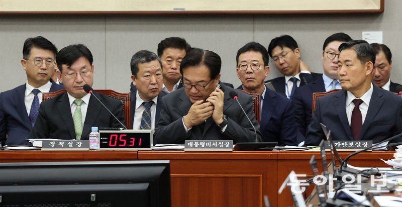 정진석 대통령비서실장(가운데)이 27일 오후 서울 여의도 국회에서 열린 운영위원회 전체회의에서 걸려온 휴대전화를 받고 있다. 앞줄
 왼쪽부터 성태윤 대통령실 정책실장, 정 비서실장, 신원식 국가안보실장. 장승윤 기자 tomato99@donga.com