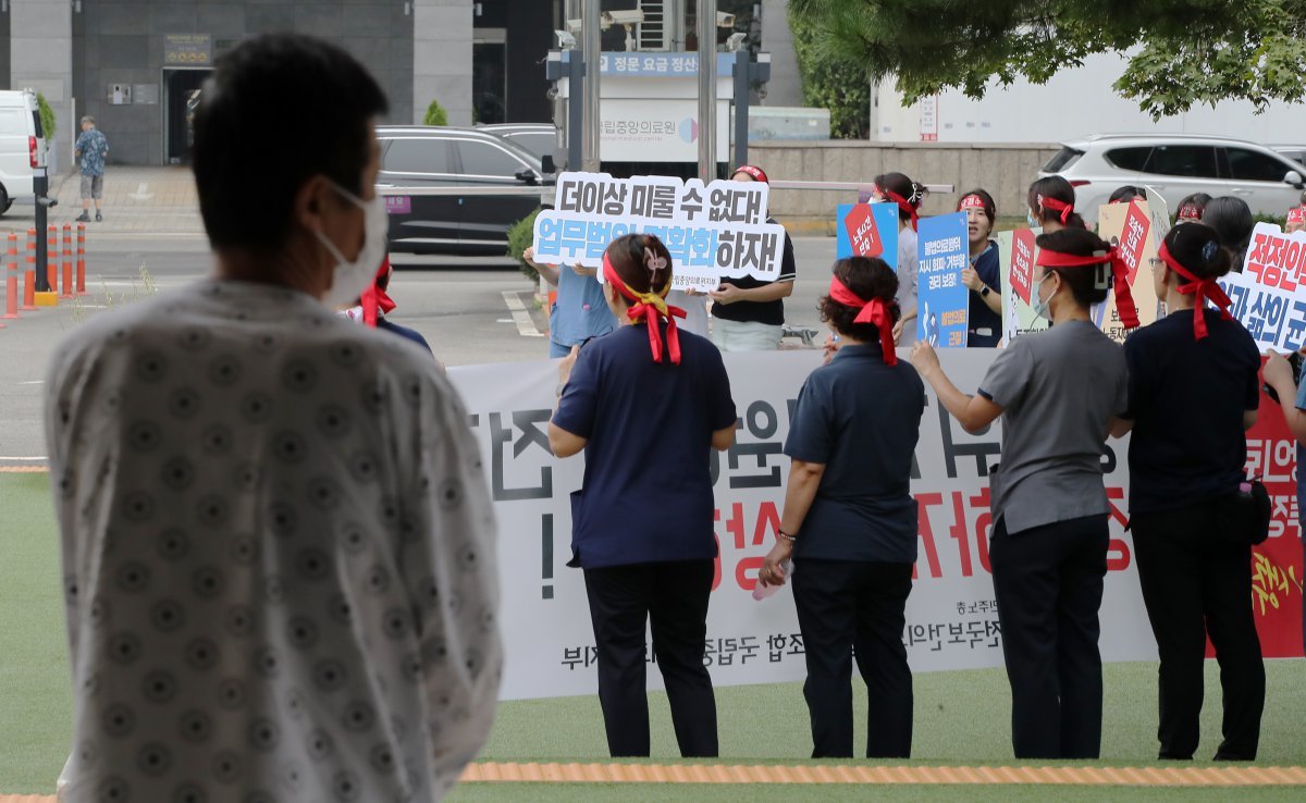 26일 한 환자가 서울 중구 국립중앙의료원 앞에서 열린 보건의료노조 국립중앙의료원지부 노조 총파업 투쟁 선전전을 바라보고 있다. 2024.8.26. 뉴스1