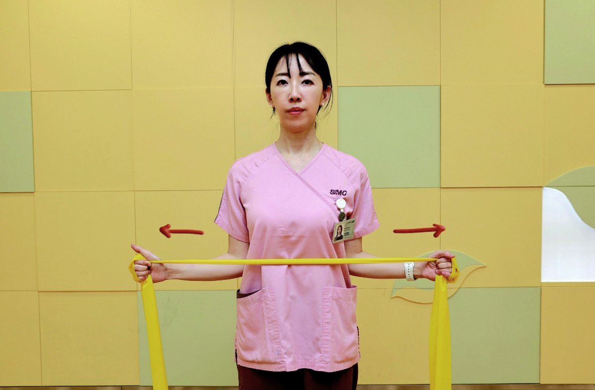 ⑥ Wrap the rubber band around both hands, bend both arms at 90 degrees and place them on your torso. Point your thumbs up and pull the band. Hold for 3 seconds and return to the starting position. Repeat 10 times.