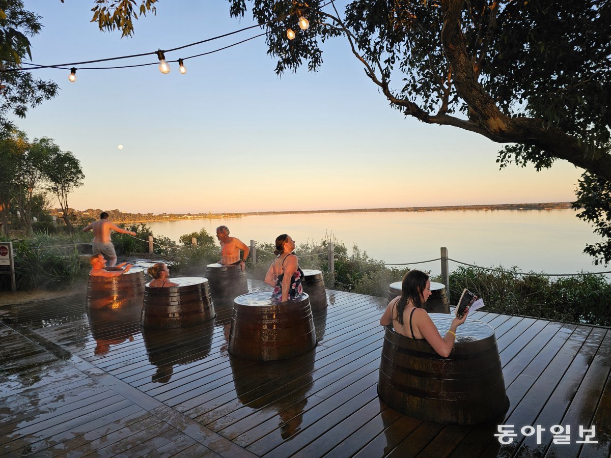 Mitung Hot Springs near Lake Gippsland, Victoria, Australia. Enjoying a hot spring bath in a wine-aging oak barrel while looking out over a pink sunset 'doesn't get any better than this'.