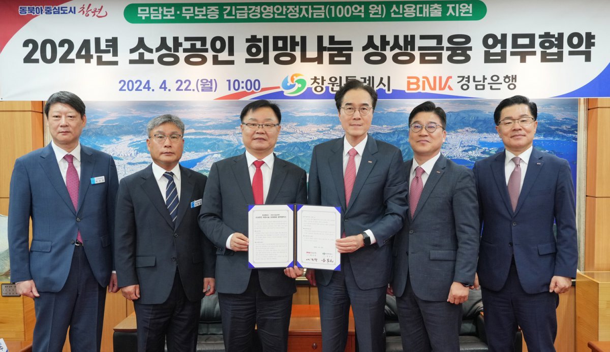 BNK경남은행은 금융위원회가 시행한 ‘2024년도 금융회사 지역재투자 평가’에서 최고 등급인 ‘최우수’를 받았다. 홍남표 창원시장(왼쪽에서 세 번째)과 예경탁 BNK경남은행장(왼쪽에서 네 번째)이 4월 22일 창원시청에서 ‘소상공인 희망나눔 상생금융’ 협약을 체결하는 모습. BNK경남은행 제공