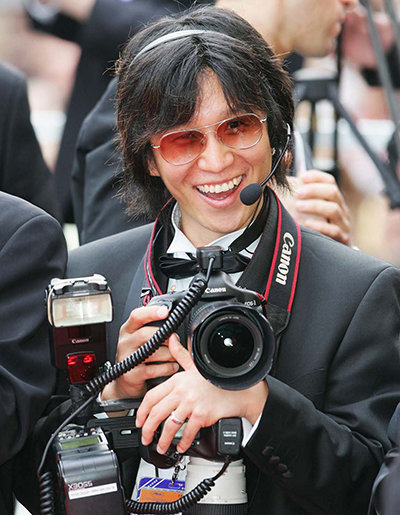 Photographer Myung-joong Kim during his time as a photojournalist at Getty Images Europe. His usual mindset is well-explained by the sight of him smiling brightly while holding a camera on site. Courtesy of photographer Myung-joong Kim.