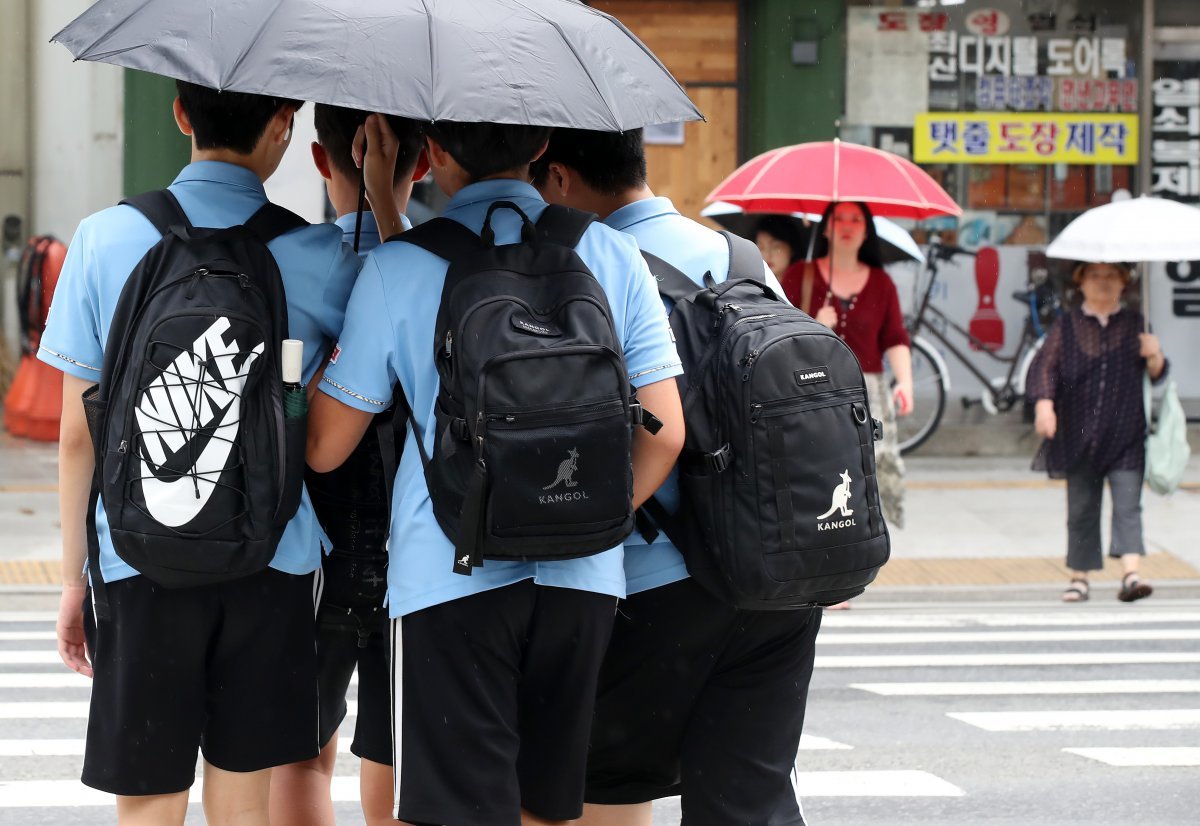 늦더위가 이어진 11일 오후 대구 중구 국채보상로 일대에 비가 내리자 하굣길 학생들이 우산 하나로 함께 비를 피하며 횡단보도를 건너고 있다. 2024.9.11/뉴스1