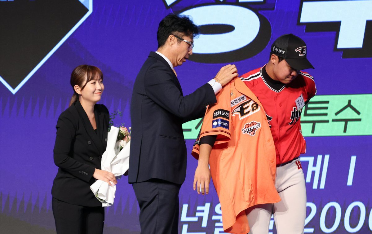 11일 오후 서울 송파구 롯데호텔 월드에서 열린 ‘2025 KBO 신인 드래프트’에서 한화 1라운드 2순위로 지명된 정우주(전주고)가 한화 손혁 단장으로부터 유니폼을 받고 있다. 2024.9.11 뉴스1