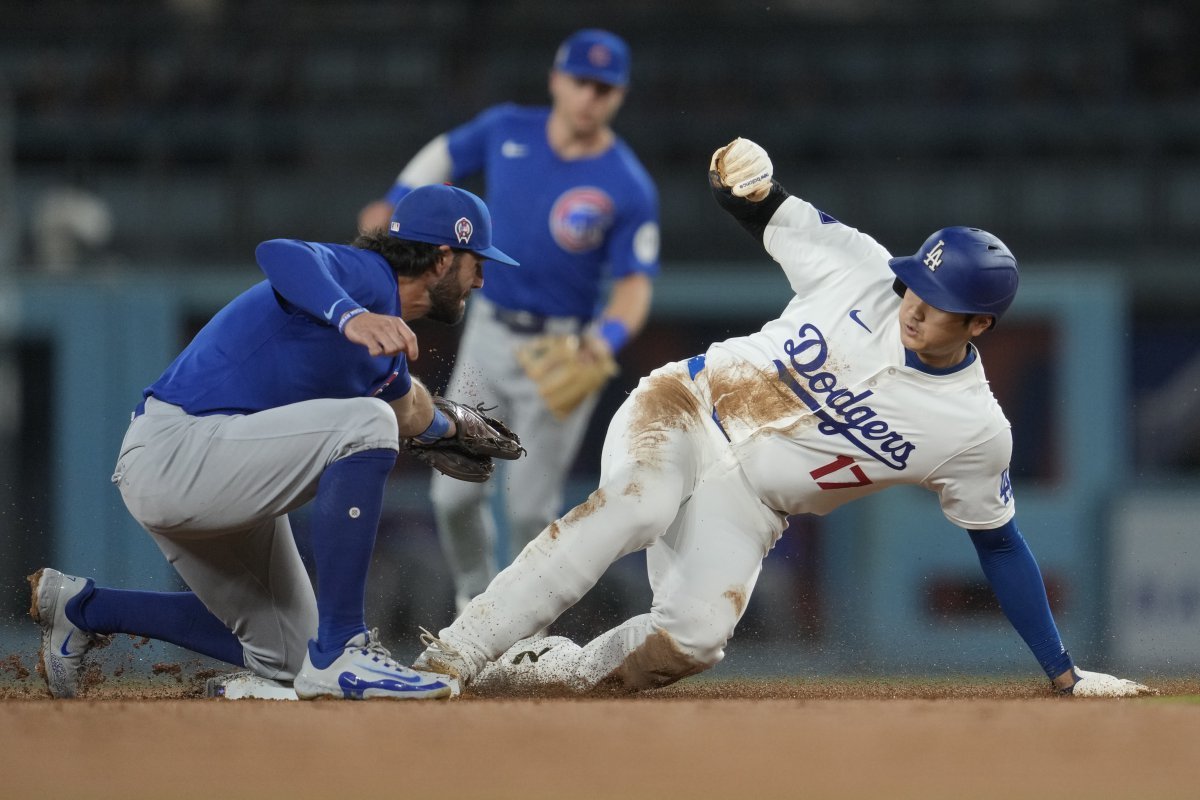 Los Angeles Dodgers designated hitter Shohei Ohtani (17) steals second base ahead of a throw to Chicago Cubs shortstop Dansby Swanson, left, during the second inning of a baseball game against the Chicago Cubs in Los Angeles, Wednesday, Sept. 11, 2024. (AP Photo/Ashley Landis)