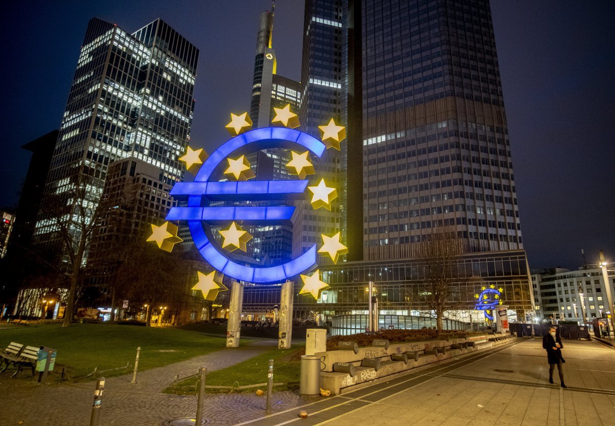 FILE  - In this Thursday, March 11, 2021 file photo, a man walks past the Euro sculpture in Frankfurt, Germany. The ECB is warning that some parts of the eurozone economy could face financial disruption from the ongoing pandemic. The central bank said COVID-19 restrictions have had an uneven impact, hitting service companies and small companies harder. (AP Photo/Michael Probst, File)