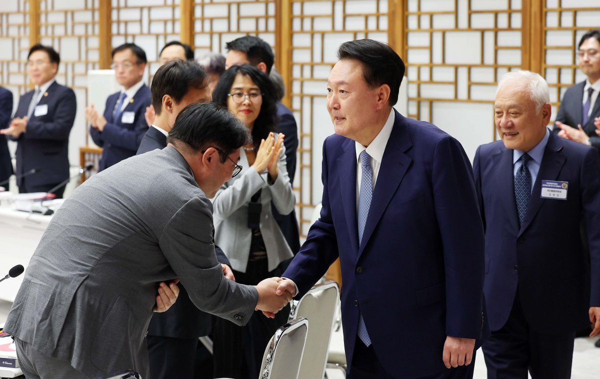 윤석열 대통령이 13일 서울 용산 대통령실 청사에서 열린 대통령 직속 국민통합위원회 성과 보고회 및 3기 출범식에 참석하며 참석자와 악수를 하고 있다. 윤 대통령은 이 자리에서 “지금 곳곳에서 계속되는 반개혁 저항에 우리가 또다시 물러선다면 나라의 미래는 기대하기 어렵다”고 말했다. 오른쪽은 김한길 국민통합위원장. 뉴시스