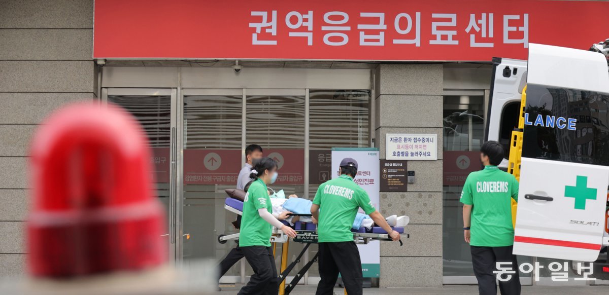 연휴 끝나자 다시 진료 제한 19일 서울 양천구 이대목동병원 권역응급의료센터 앞에서 사설 구급대원들이 환자를 옮기고 있다. 매주 수요일 야간 진료를 중단했던 이대목동병원은 추석 연휴 기간 24시간 진료를 유지한 대신 19일 야간 진료를 중단했다. 박형기 기자 oneshot@donga.com