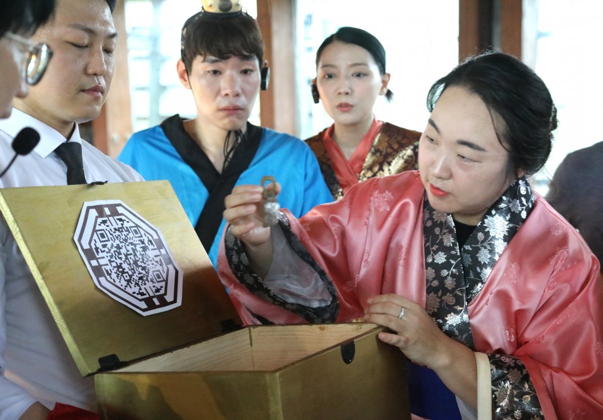 A citizen who participated in the 'Keep the Gaya Envoys!' event on the 20th is holding up a bronze belt decoration, one of the three treasures. Courtesy of the National Heritage Promotion Agency