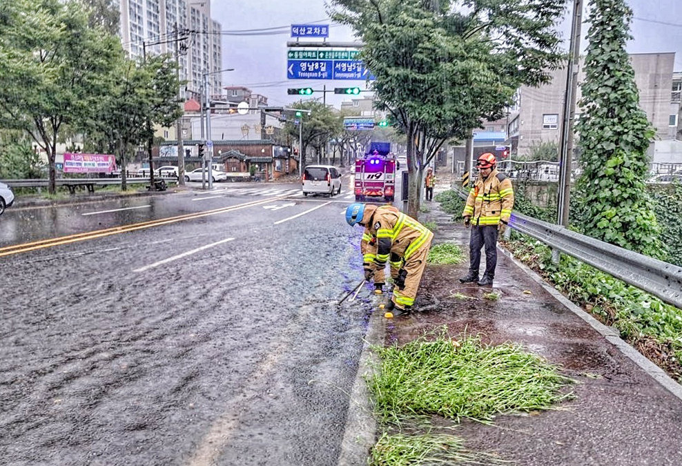 호우경보가 내려진 21일 울산 울주군 온산읍 덕산교차로에서 빗물이 역류해 소방대원이 안전 조치를 하고 있다. (울산소방본부 제공) 2024.9.21