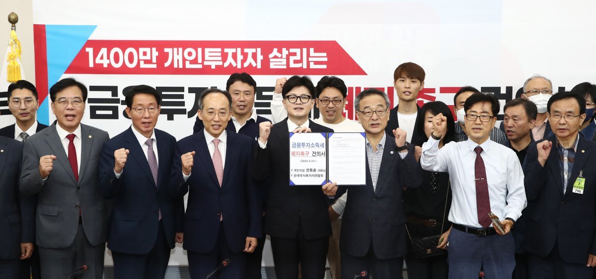 한동훈 국민의힘 대표와 추경호 원내대표, 정의정 한국주식투자자연합회 대표 및 개인투자자들이 24일 오전 서울 여의도 국회에서 열린 1400만 개인투자자 살리는 금융투자소득세 폐지 촉구 건의서 전달식에서 기념촬영을 하고 있다. 2024.9.24/뉴스1