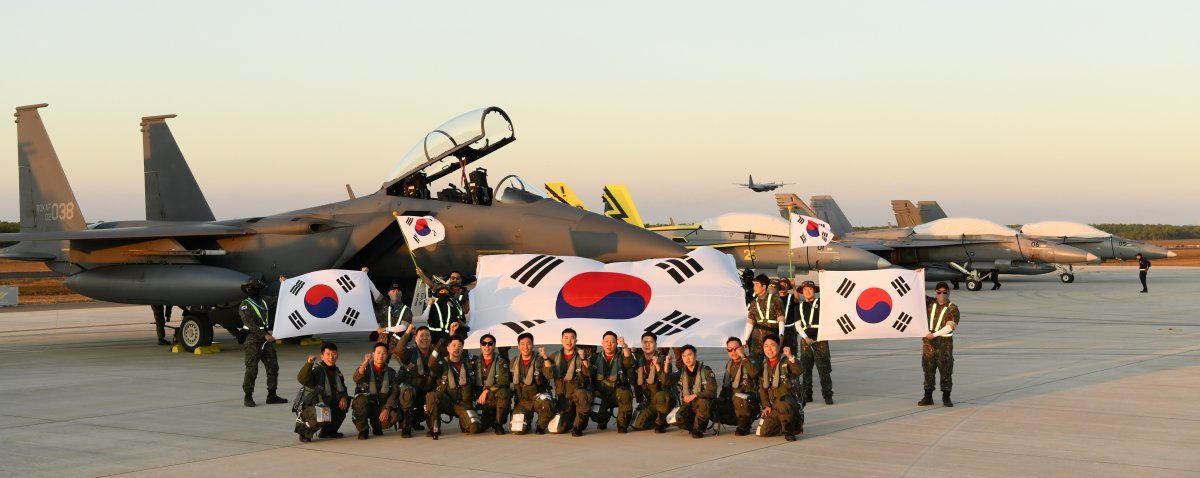 공군의 F-15K전투기 조종사들이 10일 다국적 연합공중훈련 ‘2024 피치블랙’이 실시될 호주 다윈기지에 도착해 한국 공군 F-15K와 말레이시아 공군 F-18을 배경으로 기념촬영하고 있다. 우리 공군이 자체전력만으로 무중단 페리(Ferry) 임무를 수행한 것은 이번이 처음이다. (사진=공군 제공) 2024.07.10. 뉴시스