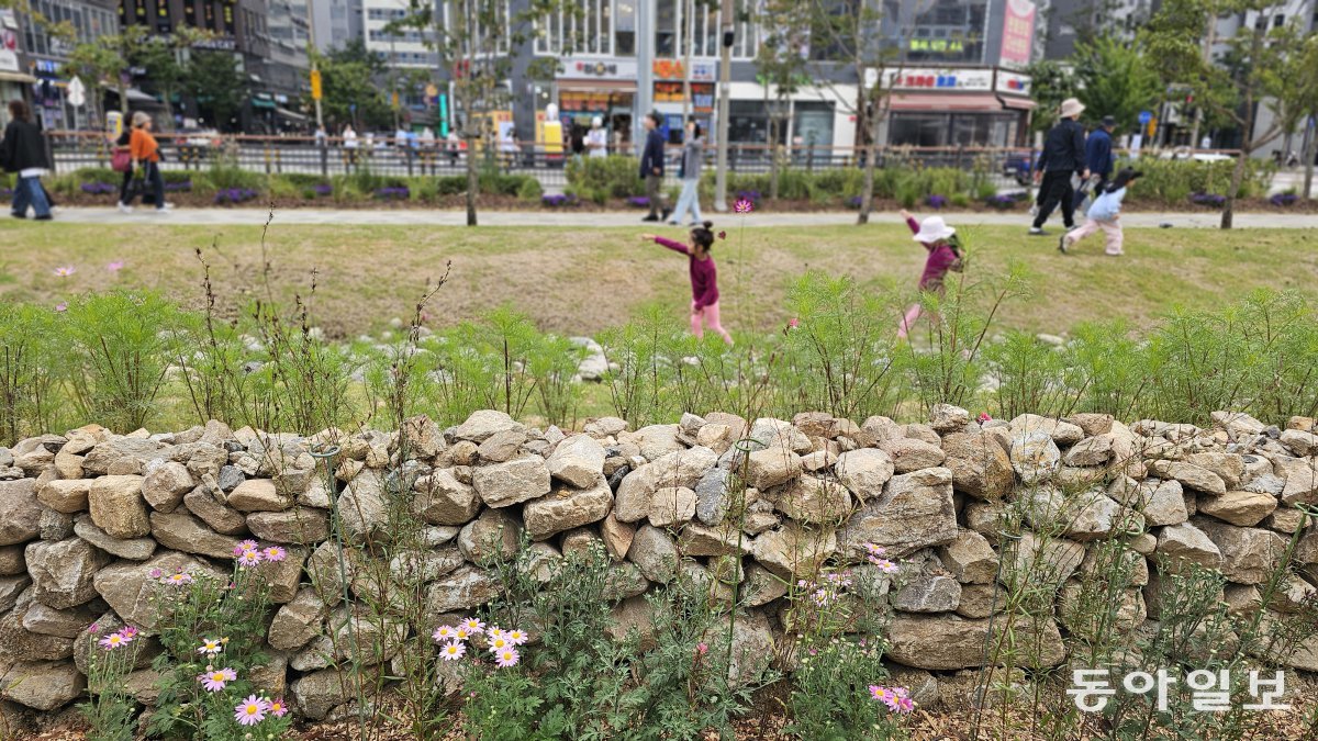 경기 남양주시 시민정원사들이 꾸민 ‘시민정원사 정원’의 돌담 너머로 신나게 걷고 있는 아이들이 보인다. 남양주=김선미 기자 kimsunmi@donga.com