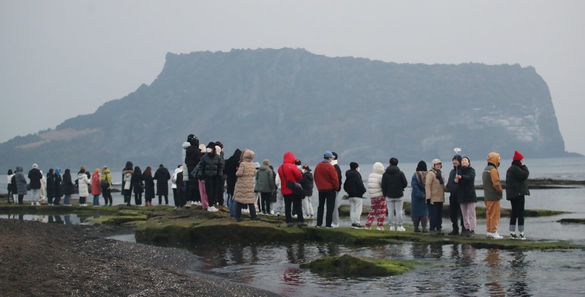 제주 서귀포시 성산읍 광치기해변에서 시민들이 성산일출봉을 바라보며 새해 첫 일출을 기다리고 있다. 2023.1.1/뉴스1