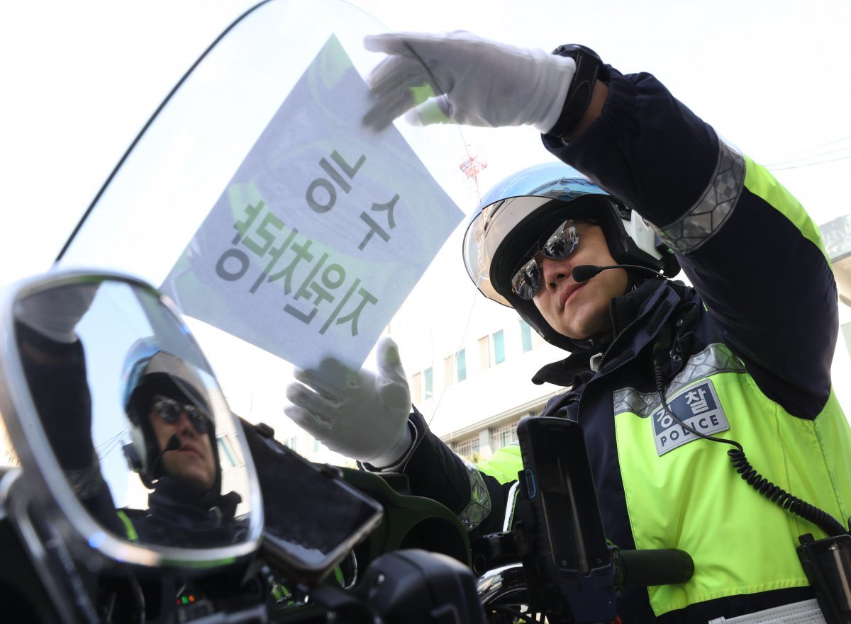 2024학년도 대학수학능력시험을 이틀 앞둔 14일 오후 경기 수원시 영통구 수원남부경찰서에서 교통안전계 경찰관들이 수능 당일 시험장 주변 특별 교통관리에 투입될 지원차량에 안내문을 부착하고 있다. 2023.11.14/뉴스1