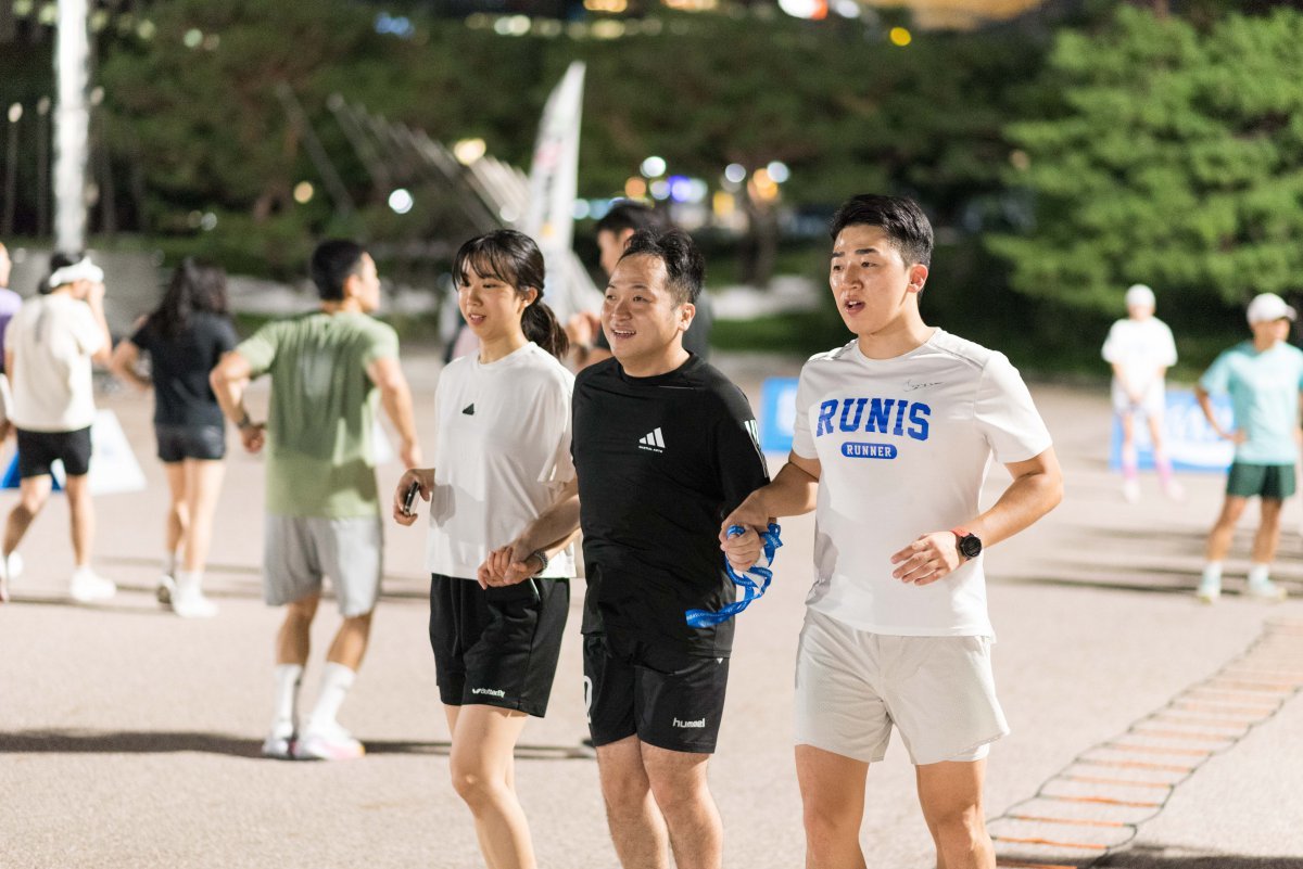 지난달 서울 영등포구 여의도공원 문화의 마당에서 ‘가이드 러닝 클래스’ 프로그램에 참여한 시민들이 시각장애인의 손을 잡고 함께 달리는 동작을 연습하고 있다. 서울시 제공