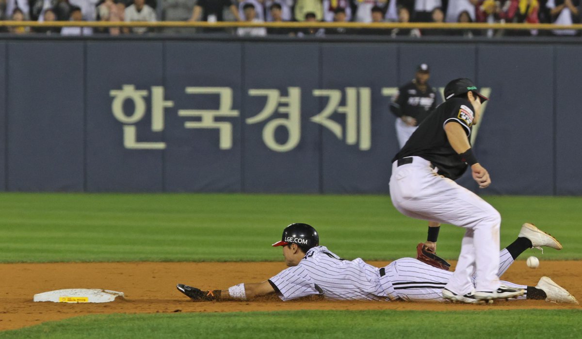 11일 오후 송파구 잠실야구장에서 열린 프로야구 ‘2024 신한 SOL 뱅크 KBO 포스트시즌’ 준플레이오프 5차전 kt 위즈와 LG 트윈스의 경기, LG 공격 3회말 1사 1루 상황에서 1루주자 신민재의 도루가 성공한 동시에 KT 수비 실책으로 공이 빠지고 있다. 2024.10.11 뉴스1