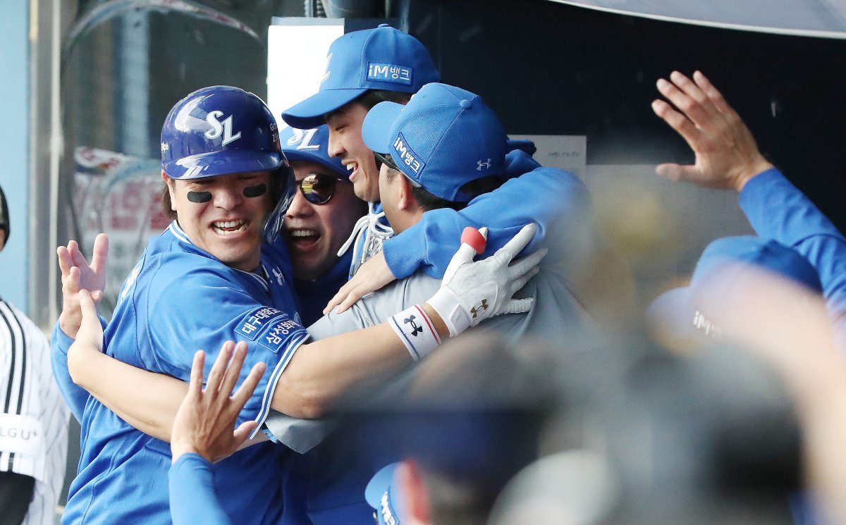 19일 오후 서울 송파구 잠실야구장에서 열린 프로야구 ‘2024 신한 SOL 뱅크 KBO 포스트시즌’ 플레이오프 4차전 삼성 라이온즈와 LG 트윈스의 경기에서 8회초 무사 주자 없는 상황 삼성 강민호가 LG 손주영을 상대로 1점 홈런을 치고 들어와 더그아웃에서 박진만 감독, 구자욱과 포옹을 하고 있다. 2024.10.19 뉴스1