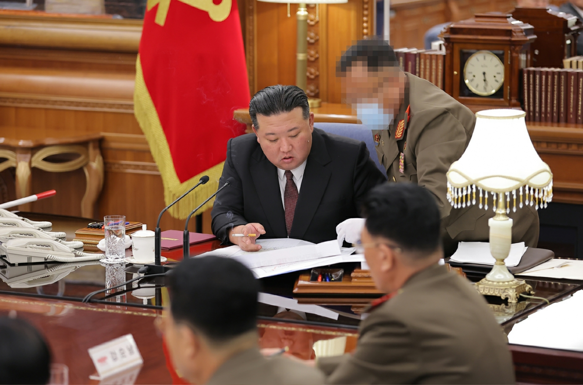 김정은 옆에서 보고하는 사람의 얼굴이 마스크와 포토샵 프로그램으로 누구인지 알아볼 수 없게 처리되어 있다. 노동신문 뉴스1