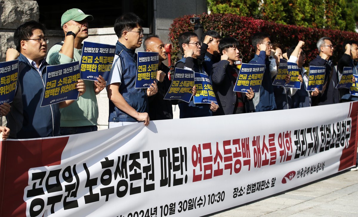 전국공무원노조 조합원들이 30일 오전 서울 종로구 헌법재판소 앞에서 열린 ‘공무원 노후생존권 파탄! 연금소득공백 해소를 위한 권리구제 헌법소원 청구’ 기자회견에서 공무원 연금소득공백 해소를 촉구하는 구호를 외치고 있다. 2024.10.30/뉴스1