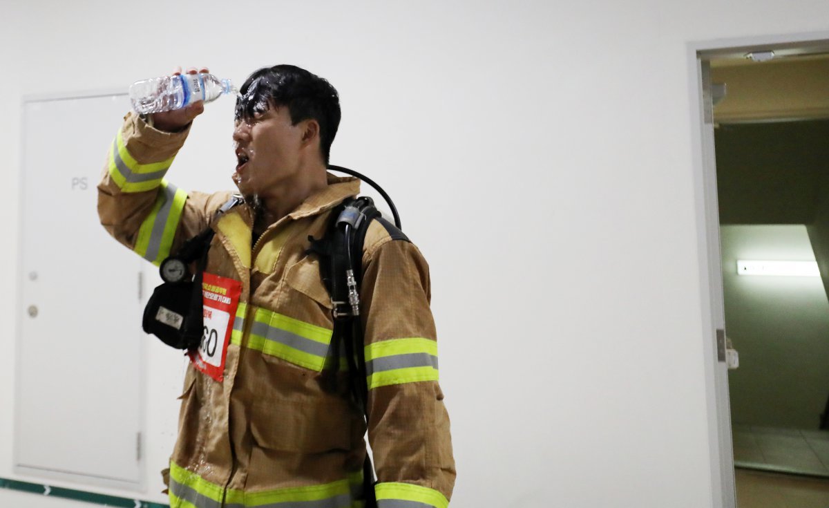 30일 부산 해운대구 엘시티에서 열린 전국소방고무원 엘시티 계단오르기 대회에서 참가자가 물로 더위를 식히고 있다. 2024.10.30/뉴스1