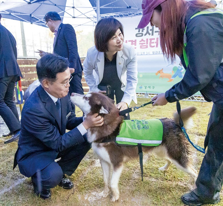 진교훈 강서구청장(왼쪽)이 황금내근린공원에 조성된 반려견 쉼터를 찾은 반려견과 교감 중이다. 강서구 제공