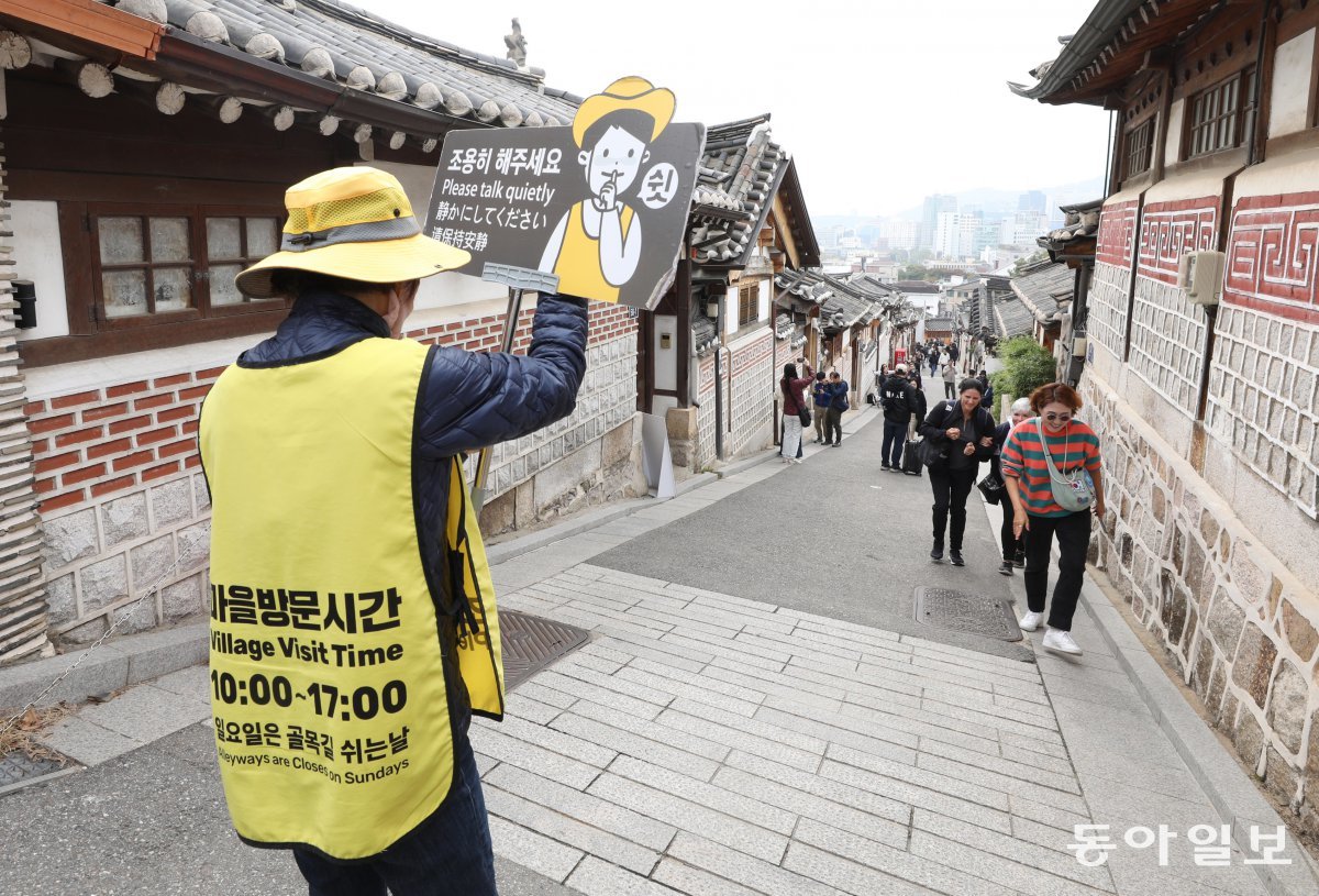 1일 오전 서울 종로구의 북촌 한옥마을에서 노란색 조끼를 입은 ‘북촌 지킴이’가 관광객 출입 가능 시간(오전 10시∼오후 5시)을 알리는 조끼를 입고 피켓을 들고 있다. 일요일에는 출입이 전면 제한된다. 종로구는 북촌 특별관리지역(북촌로 11길 일대)에 대해 1일부터 방문 시간을 제한하기 시작했다. 신원건 기자 laputa@donga.com