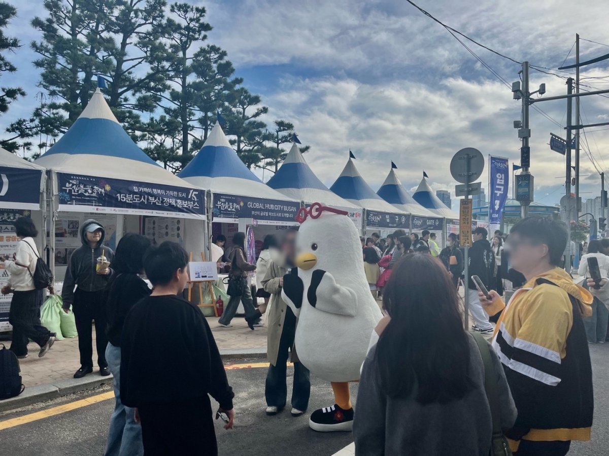 9일 오후 부산 광안리해수욕장 인근 도로에서 부산시 마스코트 부기가 방문객과 사진을 찍고 있다.2024.11.9