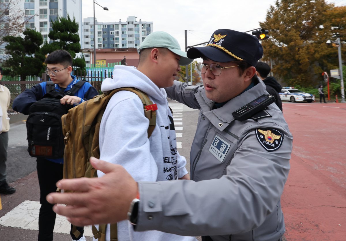 2025학년도 대학수학능력시험일인 14일 오전 광주시교육청 26지구 제2시험장인 광산구 정광고등학교 앞에서 10시간 걸려 시험보러온 해병대 수험생에게 학부모 대신 경찰들이 응원의 포옹을 해주고 있다. 2024.11.14./뉴스1