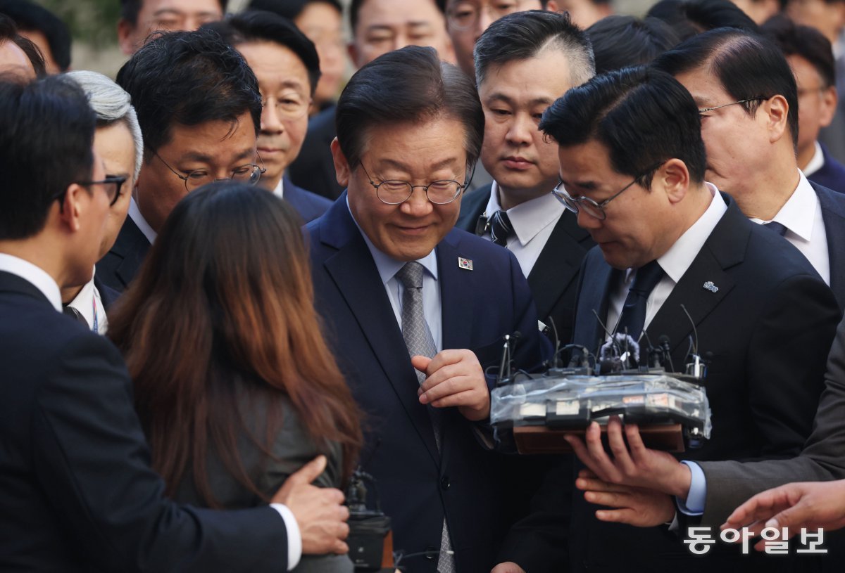 더불어민주당 이재명 대표가 15일 오후 서울 서초구 서울중앙지방법원에서 열린 공직선거법 위반 1심 선고 공판에 출석해 민주당 의원들의 ‘방탄의전’을 받으며 법정으로 향하고 있다. 민주당 김민석 최고위원(왼쪽 첫 번째)이 방송기자가 무선 마이크를 떨어뜨린 뒤 다시 이 대표에게 질문하자 “다쳐요. 다쳐”라고 말하며 기자를 옆으로 밀어내고 있다. 박형기 기자 oneshot@donga.com