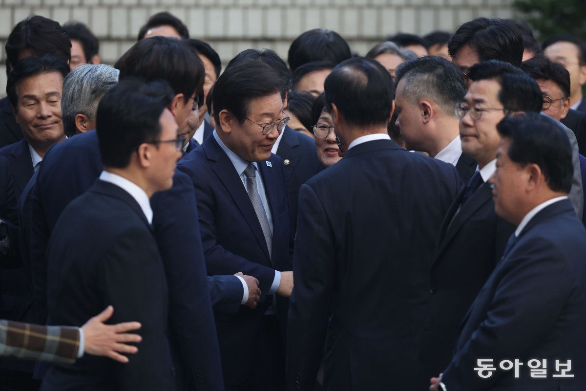 이재명 대표가 법원에 도착한 뒤, 차에서 내려 동료 의원들과 인사하고 있다. 이 대표가 도착하자 흩어져 있던 의원들은 이 대표 주위로 몰려들기 시작했다. 박형기 기자 oneshot@donga.com