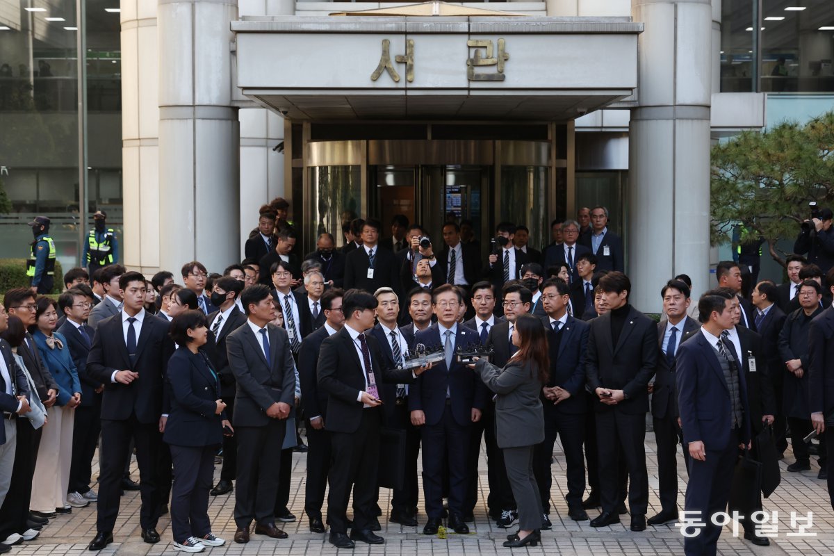 1심 선고를 받고 법정 앞에서 입장을 밝히는 이재명 대표 주위로 더불어민주당 의원들이 몰려있다. 박형기 기자 oneshot@donga.com