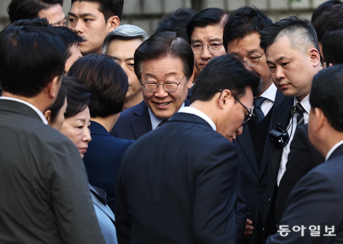 이재명 대표가 15일 공직선거법 위반 사건 1심 선고를 받기 위해 서울중앙지법으로 들어서면서 활짝 웃고 있다. 이 대표는 이날 자신을 배웅나온 71명의 현역 의원들과 악수하며 들어갔다. 양회성 기자 yohan@donga.com