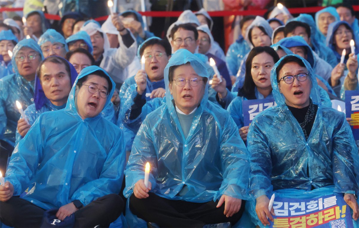 촛불 조명 든 이재명 더불어민주당 이재명 대표(앞줄 가운데)가 16일 서울 광화문 인근에서 당 주최로 열린 ‘김건희·윤석열 국정농단 규탄 및 특검 촉구’ 집회에서 우비를 입은 채 손에 촛불 조명을 들고 구호를 외치고 있다. 전날 공직선거법 위반 혐의 1심에서 징역 1년에 집행유예 2년을 선고받은 이 대표는 이날 연단에 올라 “이재명은 결코 죽지 않는다”고 목소리를 높였다. 이 대표 왼쪽은 박찬대 원내대표, 오른쪽은 김민석 수석최고위원이다. 뉴스1