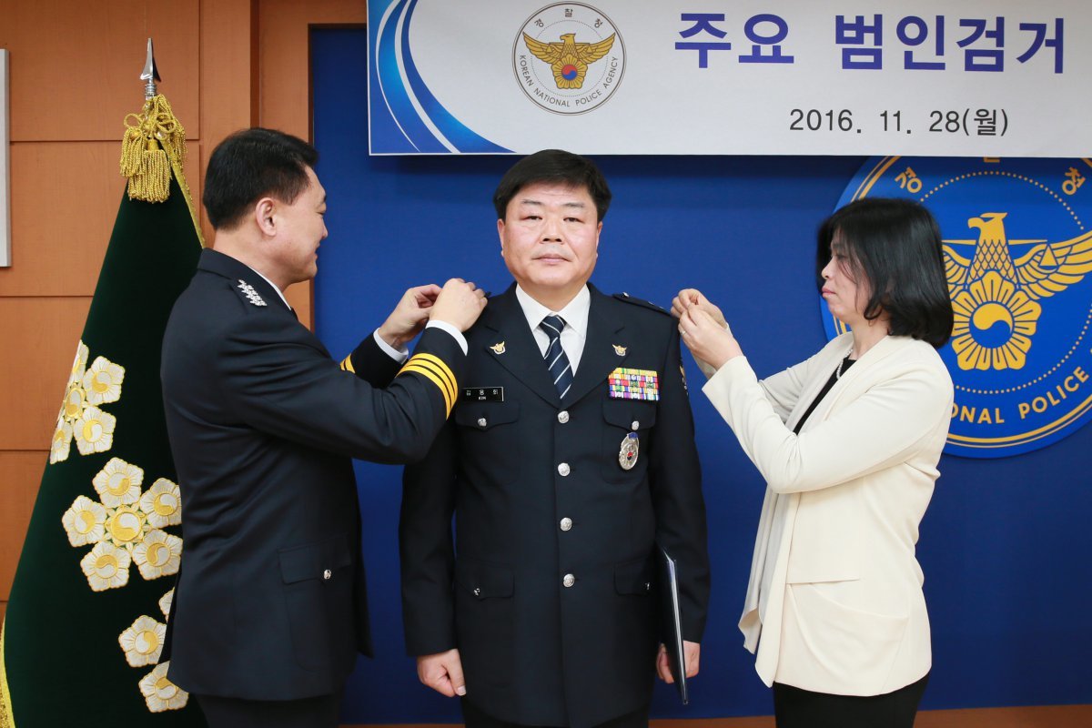 2016년 11월 28일 이철성 경찰청장이 서울 서대문구 경찰청에서 열린 ‘주요 범인검거 특별승진 임용식’에서 18년 전인 1998년 서울 노원에서 발생한 가정주부 살해사건 범인을 검거한 유공경찰관 김응희 경감(경위에서 1계급 특진)에게 계급장을 달아주고 있다. (경찰청 제공) 2016.11.28/뉴스1