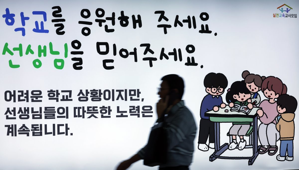 서이초 교사 순직 1주기를 앞두고 실천교육교사모임이 게시한 지하철 추모 광고 앞으로 시민이 지나고 있다. /뉴스1 ⓒ News1ㅌ