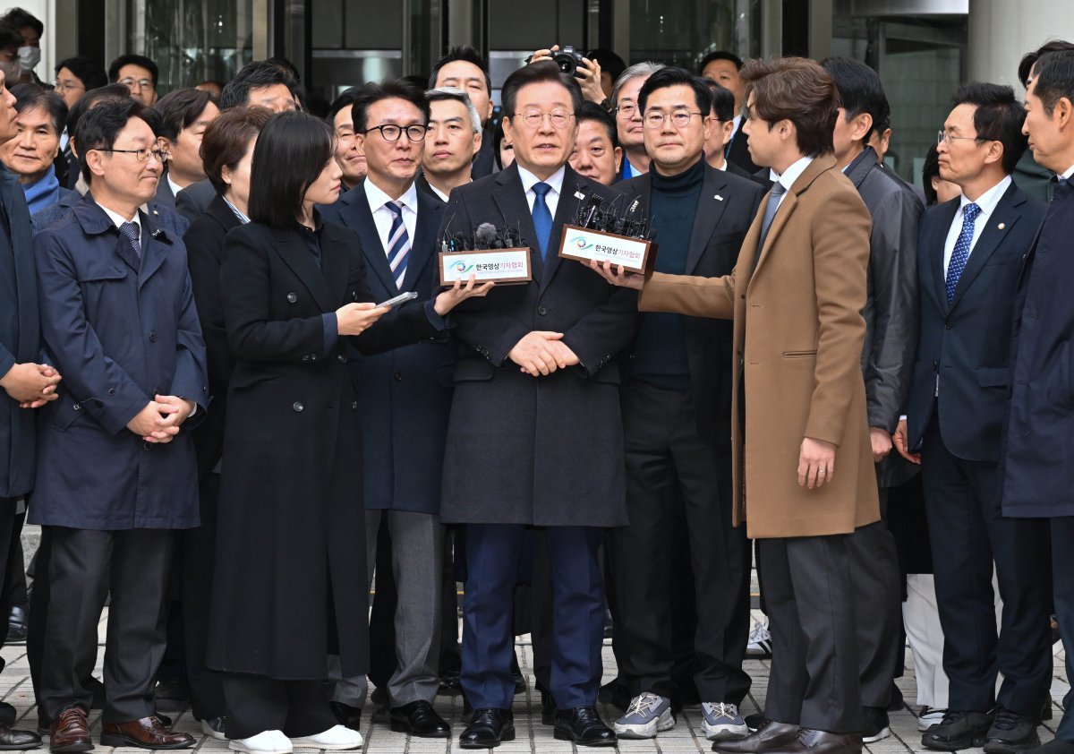 더불어민주당 이재명 대표가 25일 서울 서초구 중앙지방법원에서 열린 위증교사 혐의 1심에서 무죄를 선고받은 뒤 법원을 나서며 발언하고 있다. 이 대표 뒤로 이 대표를 배웅나온 민주당 의원들이 줄지어 서 있다. 사진공동취재단