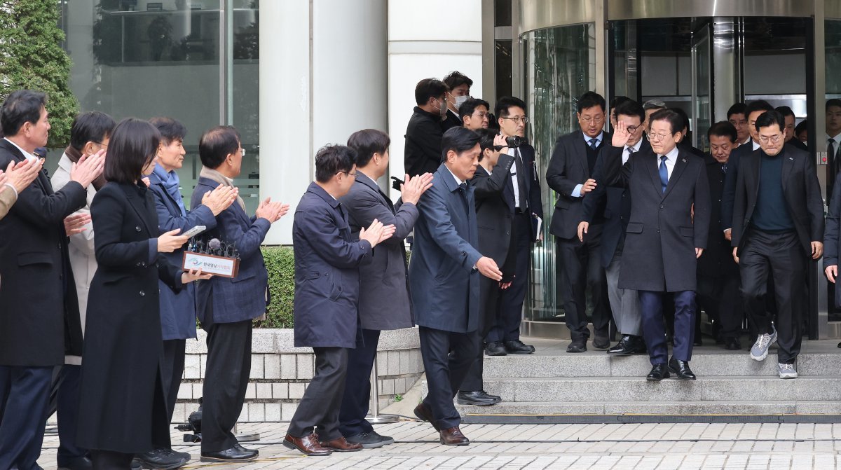 더불어민주당 이재명 대표가 25일 서울 서초구 중앙지방법원에서 열린 위증교사 혐의 1심에서 무죄를 선고받은 후 기다리고 있던 민주당 의원들의 박수를 받으며 법원을 나서고 있다. 사진공동취재단