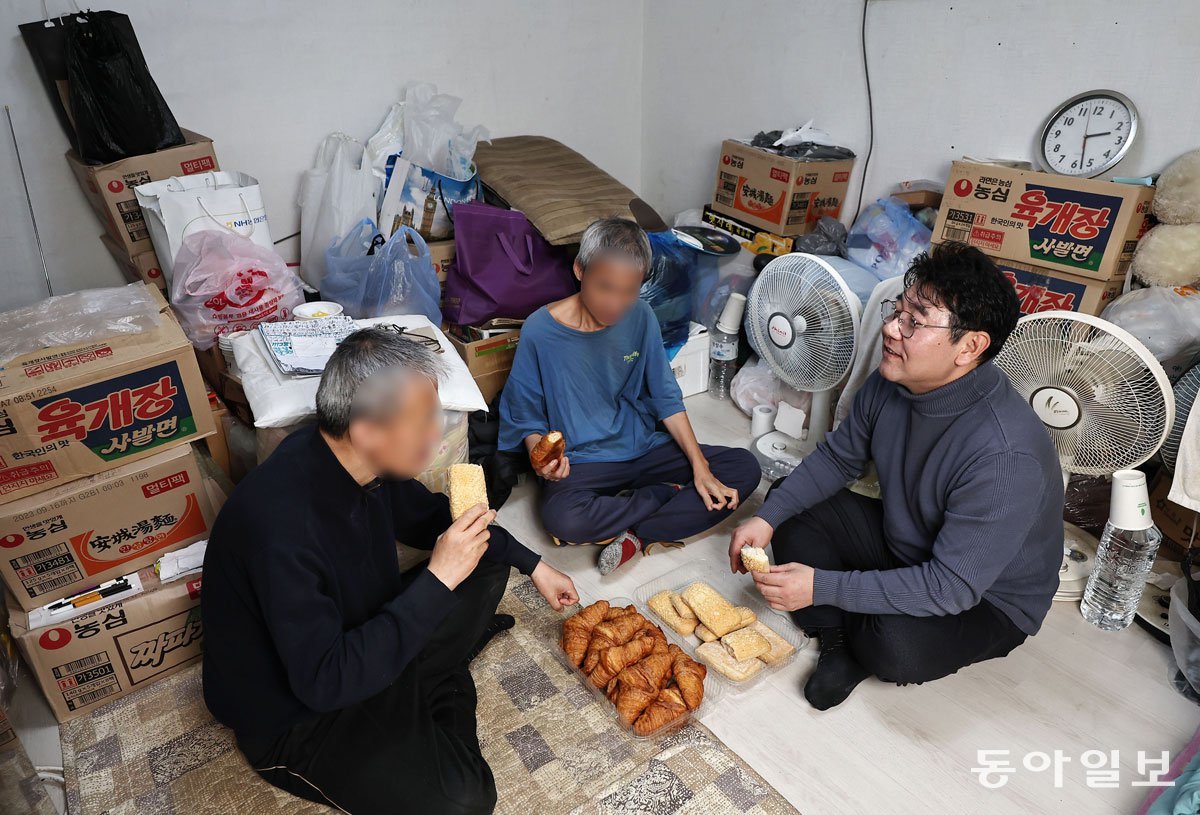 김재영 목사(오른쪽)가 2일 서울 동작구 상도동 자택에서 김유기, 김락기 형제와 함께 교회 후원으로 들어온 빵을 나눠 먹고 있다. 김 목사는 발달장애가 있는 이들 형제와 6년째 함께 지내고 있다. 양회성 기자 yohan@donga.com