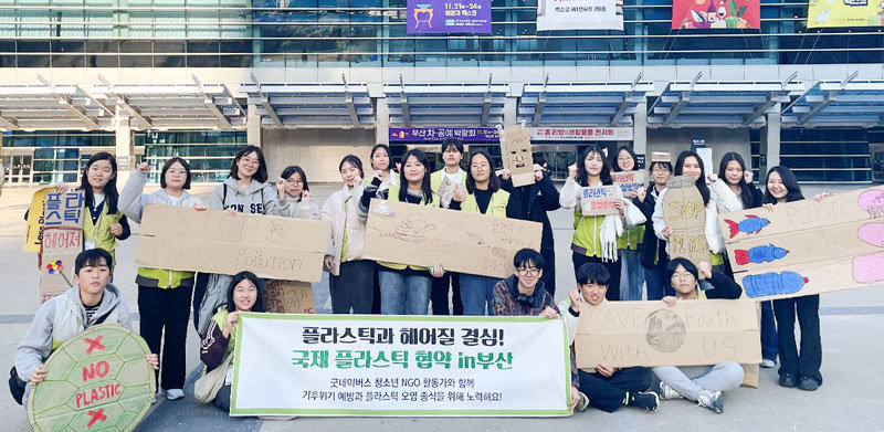 지난달 23일 ‘국제 플라스틱 협약’을 위한 제5차 정부 간 협상위원회(INC) 회의가 열린 부산 벡스코 앞에서 굿네이버스 청소년 NGO 활동가들이 ‘플라스틱 오염 종식’ 등의 문구가 적힌 종이판을 들고 있다. 굿네이버스 제공