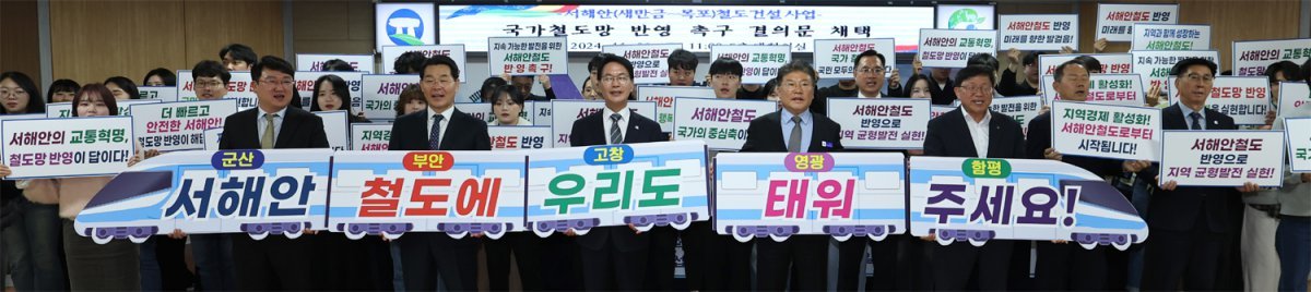 전북 고창군청 대회의실에서 열린 ‘서해안 철도 국가계획 반영 촉구 결의 기자회견’ 직후 참가자들이 손팻말을 들고 퍼포먼스를 하고 있다. 고창군 제공