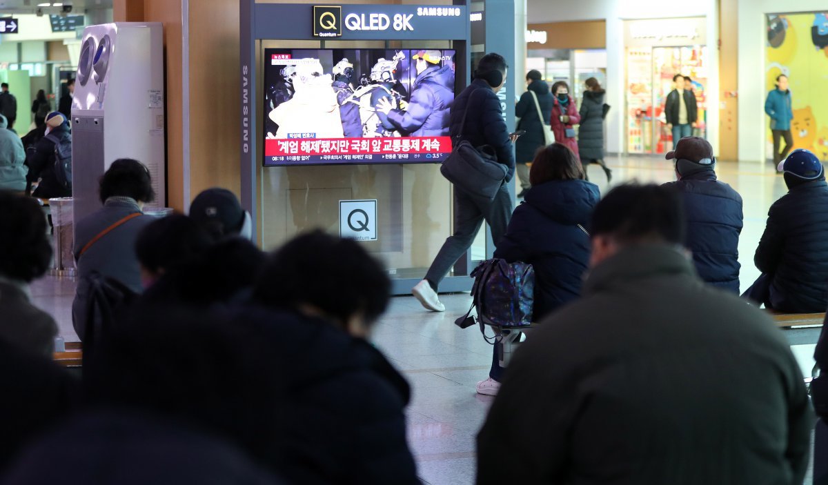 윤석열 대통령이 비상계엄 해제를 선언한 4일 오전 서울역 대합실에서 시민들이 관련 뉴스를 보고 있다. 2024.12.04. [서울=뉴시스]