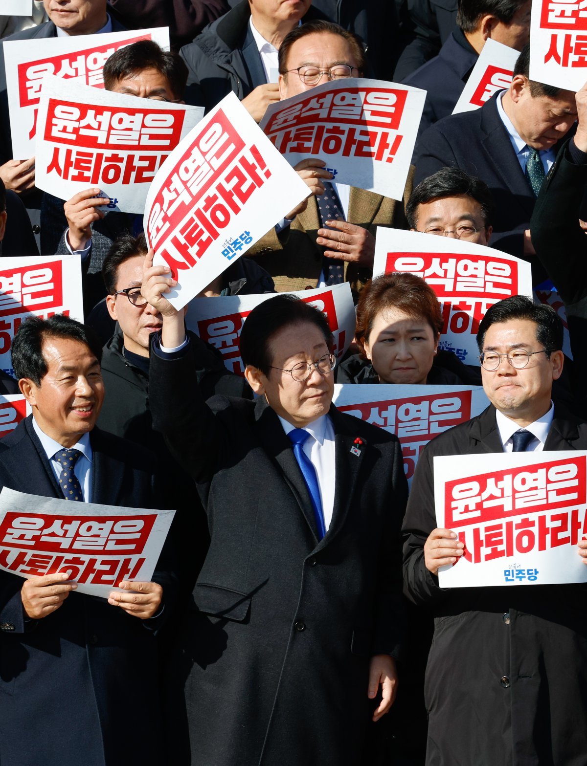 이재명 더불어민주당 대표가 4일 서울 여의도 국회 본청 계단에서 열린 ‘윤석열 대통령 사퇴촉구 탄핵추진 비상시국대회’에서 ‘윤석열은 사퇴하라!’라고 적힌 손팻말을 들고 있다. 2024.12.4/뉴스1